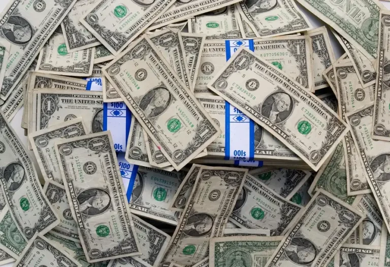 A stack of cash featuring blue and white striped bills arranged in a neat pile.