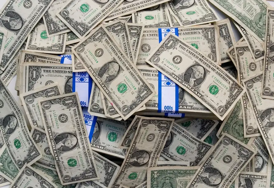 A stack of cash featuring blue and white striped bills arranged in a neat pile.